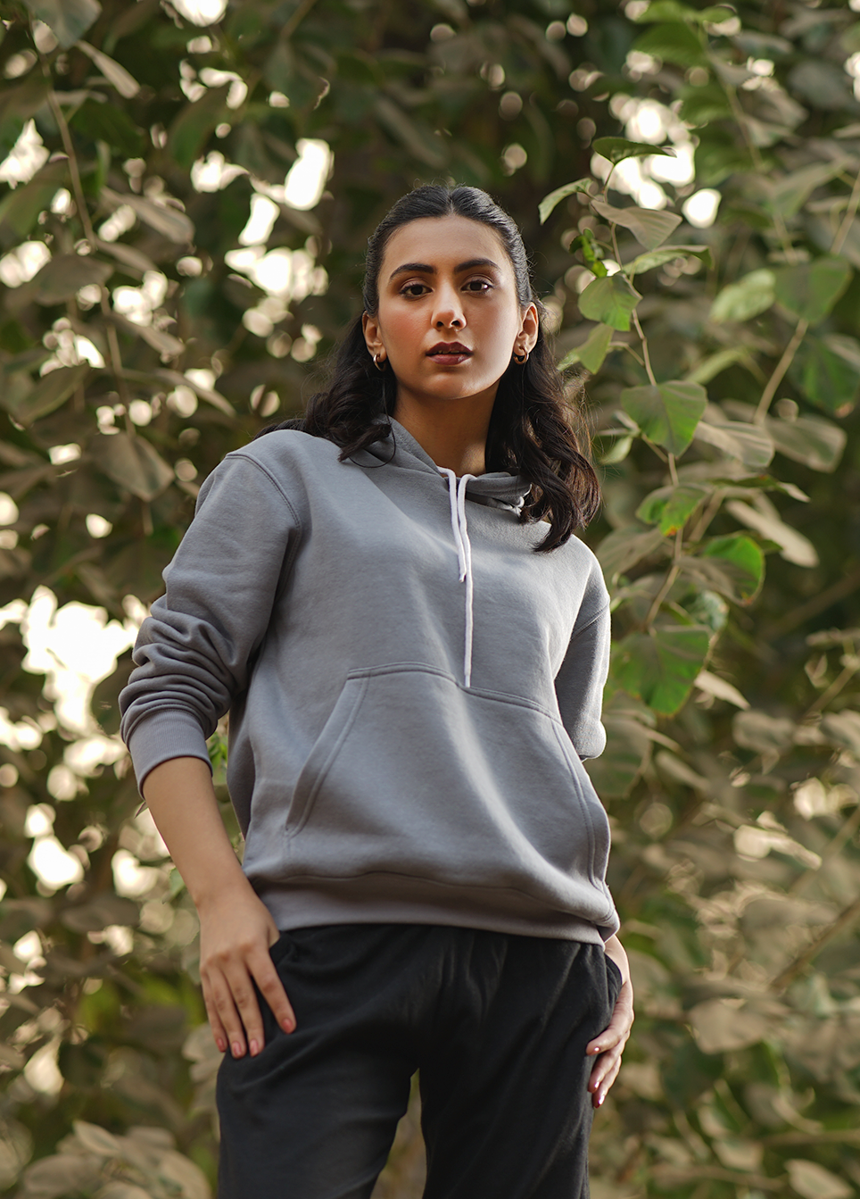 Woman wearing a gray hoodie and black pants